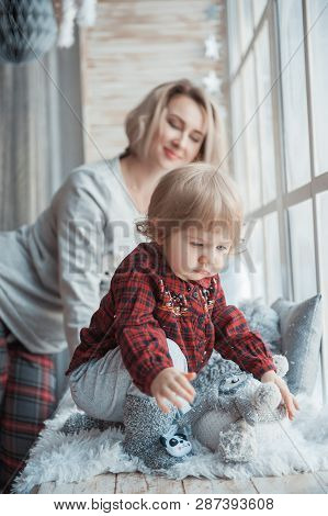 Mother With A Little Daughter. Family In Home Clothes.