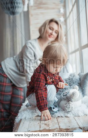 Mother With A Little Daughter. Family In Home Clothes.