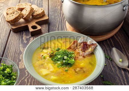 Fragrant Yellow Split Pea Soup  With Smoked Pork Ribs  On A Wooden Table.