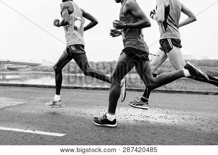 Group Runners Leaders Run Along Embankment Of River Black-and-white Image