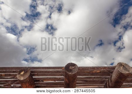 Blue Sky With Clouds Over Exposed Vigas And Latillas, Adobe Exterior Construction Details, Horizonta
