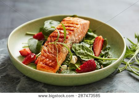 Spinach and strawberry salad with grilled salmon