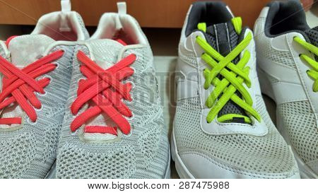 Beautiful Method Of Shoelace Tying. Colorful Neon Pink And Lime Green Shoelaces On White Sneakers