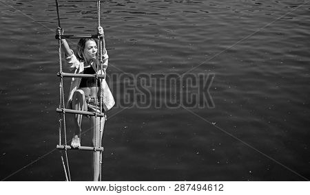 The Highest Ambition. Sensual Woman Hang On Rope Over Water Surface. Pretty Woman Climb Jacobs Ladde