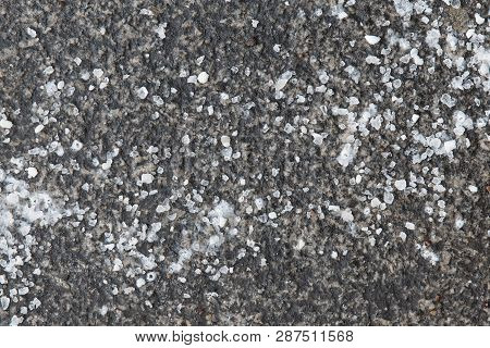 De-icing Chemicals On The Asphalt Road. Pavement Is Sprinkled With Technical Salt Or Salt Mixtures B