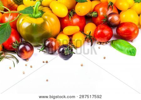 Assorted tomatoes and vegetables isolated on white background. Photo for your design