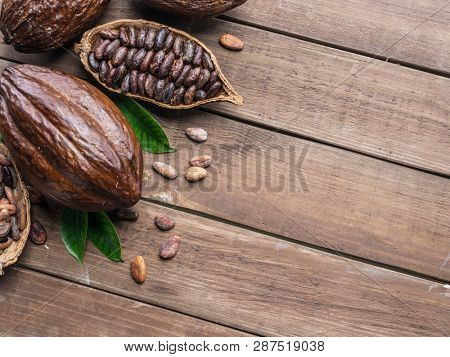 Cocoa pod and cocoa beans on the wooden table. Top view.