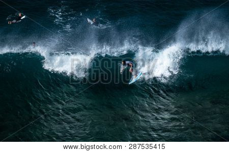 MAUI / USA - 14 DECEMBER 2018: Young surfer rides powerful ocean wave at Honolua surf spot on the north of Maui