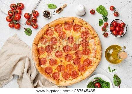 Tasty Pepperoni Pizza On White Background. Pizza, Olive Oil, Cherry Tomatoes, Green Leaf Salad Mango