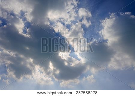 Sunburst Clouds On Blue Sky Hiding The Sun