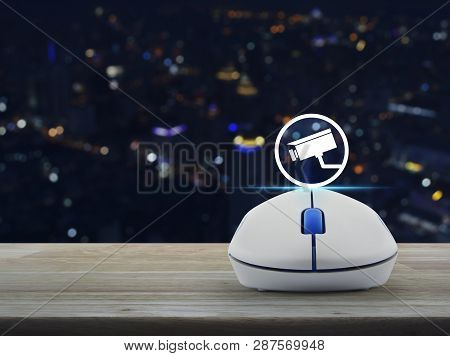 Cctv Camera Icon With Wireless Computer Mouse On Wooden Table Over Blur Colorful Night Light City To