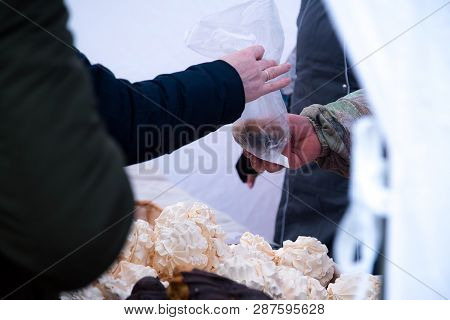 Costumer Buying Ecler Pastry Covered With Chocolate At The Food Market