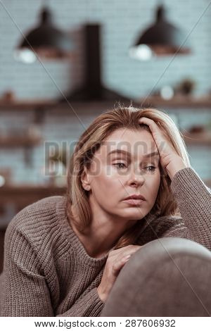 Blonde-haired Businesswoman Sitting In The Kitchen At Home
