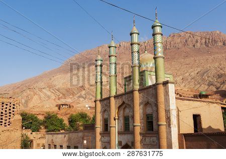 The Facade Of The Mosque At The Uyghur Village Of Tuyog, With Mountains On The Background, Xinjiang 