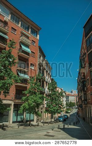 Building With Bricks Facade And Trees On A Quiet Street In Madrid