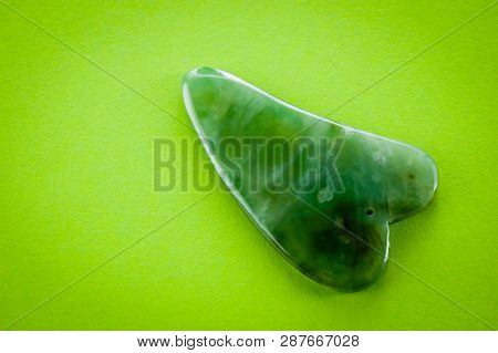 Guasha Scrapers For Body Massage According To The Ancient Method Shot On A Bright Green Background