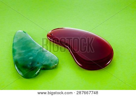 Guasha Scrapers For Body Massage According To The Ancient Method Shot On A Bright Green Background