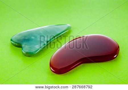 Guasha Scrapers For Body Massage According To The Ancient Method Shot On A Bright Green Background