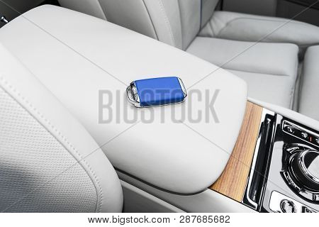 Closeup Inside Vehicle Of Wireless Blue Leather Key Ignition On Natural Wood Panel. Wireless Start E