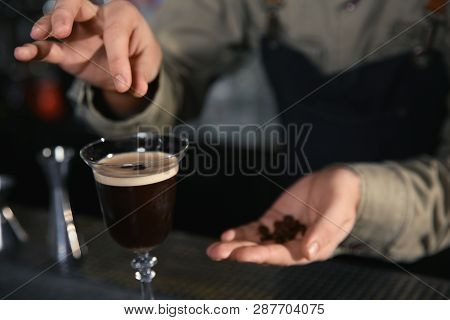 Barman Adding Coffee Bean To Martini Espresso Cocktail At Counter, Closeup. Space For Text