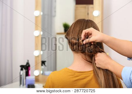 Professional Coiffeuse Braiding Client's Hair In Salon