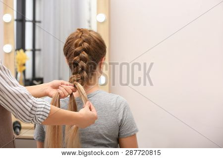 Professional Coiffeuse Braiding Client's Hair In Salon