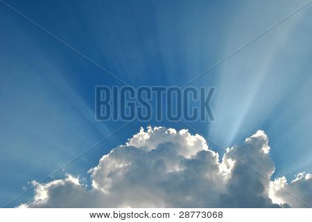 Céu azul com nuvens e raio de luz