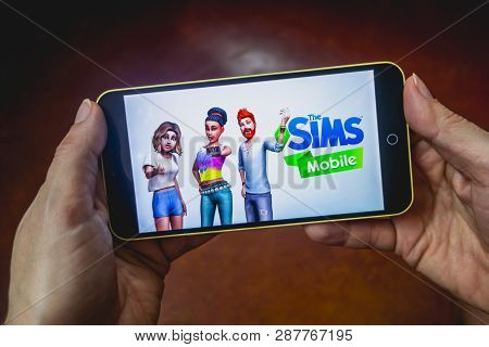 Berdyansk, Ukraine - March 4, 2019 - Close Up Of Hand Of Person Playing The Sims Mobile Game Apllica