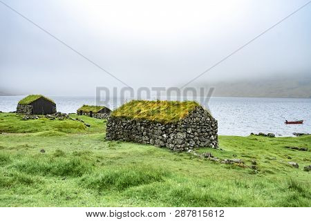Beautiful Fisherman Rock House With Green Grass On The Roof, Sea Side Next To Blue Ocean With Boat I