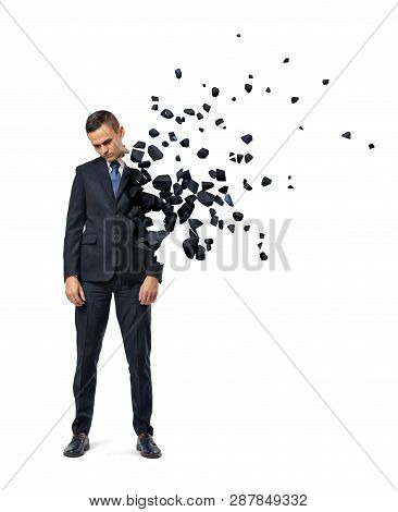Young Sad Businessman Shattering Into Small Pieces On White Background