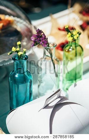 Fresh Little Multicolored Statice Salem Or Limonium Sinuatum Flowers In Blue, White And Green Bottle