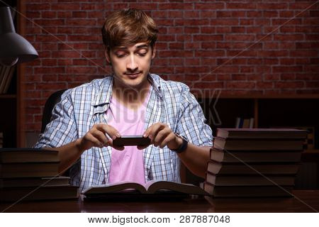 Young handsome student preparing for exams at night 