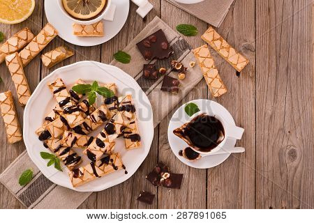 Puff Pastry Cookies With Chocolate Icing On White Dish.