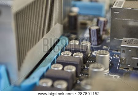 Macro Photograph Of Blue Pc Motherboard. Detailing Its Conectors, Coolers And Components.