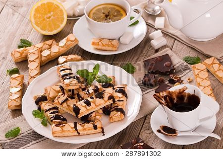 Puff Pastry Cookies With Chocolate Icing On White Dish.