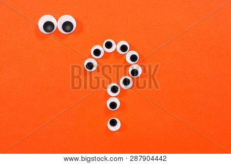 Googly Eyes. Strange Persons With Mad Eyes Look At Some Crazy Toy Eyes On Orange Background. In The 