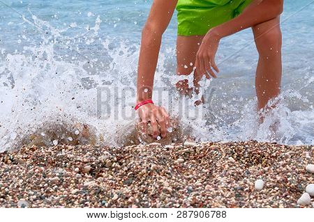 Active Children Summer Vacation At Sea. Sunburnt School Boy Builds A Tower Of Stones On Sea Coast. S