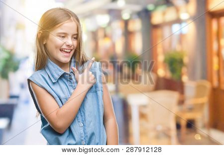 Young beautiful girl over isolated background cheerful with a smile of face pointing with hand and finger up to the side with happy and natural expression on face looking at the camera.