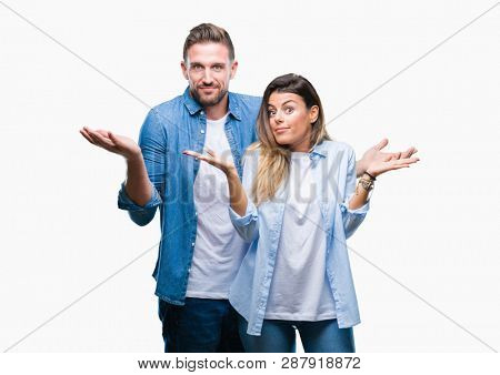 Young couple in love over isolated background clueless and confused expression with arms and hands raised. Doubt concept.