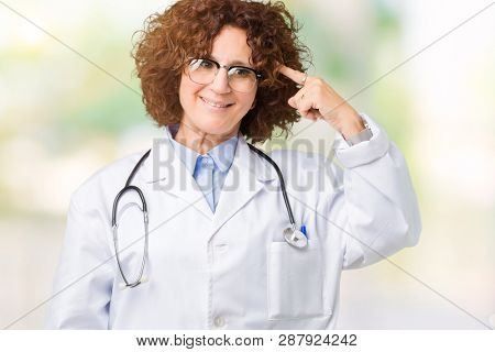 Middle ager senior doctor woman over isolated background Smiling pointing to head with one finger, great idea or thought, good memory