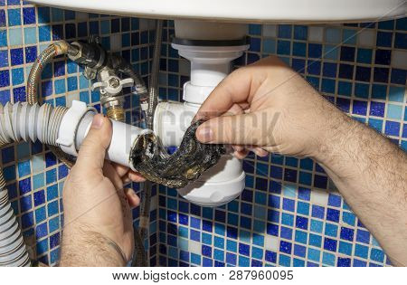 The Plumber Removes The Blockage In The Pipes, Disassembles The Siphon And Pulls Out The Dirt. Close