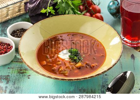 Red Beetroot Soup Borshch With Beef And Sour Cream On Blue Wooden Table