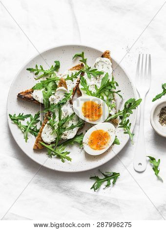 Delicious Breakfast, Brunch Or Snack - Cream Cheese Toast, Arugula Salad And Soft Boiled Egg On A Li