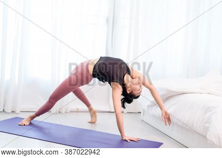 Young Woman Do Yoga In A Bed Room