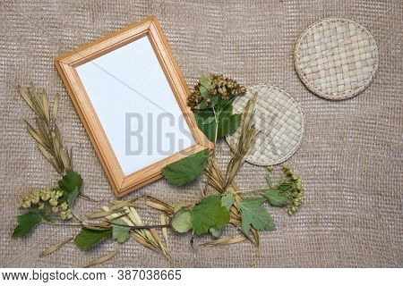 Top View Flat Lay Autumn Composition. Blank Brown Frame, Dried Barbed Plants, Straw Work And Sackclo