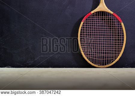 Vintage Badminton Racket On A Black Background. Badminton Racket On Plywood. Racket And Shuttlecock 