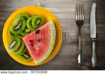 Watermelon And Kiwi Sliced On A Yellow Plate Or A Black Wooden Background .watermelon And Kiw With F