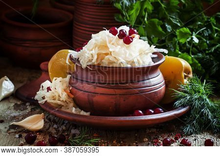 Traditional Russian Sauerkraut With Pickled Apples And Cranberries In A Clayware, Black Background, 