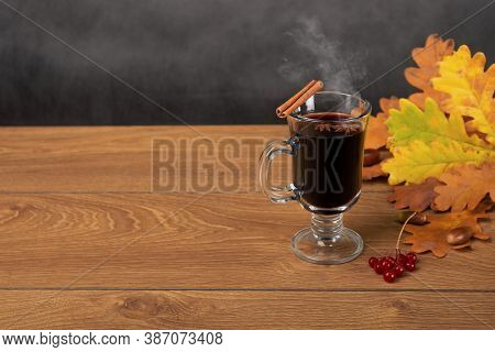 Mulled Wine And Autumn Fallen Leaves. Still Life A Mug Of Mulled Wine With Cinnamon Stick Stands On 