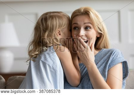 Naughty Preschool Girl Whispering Joke On Amazed Grown Sister Ear